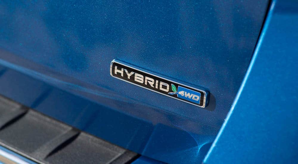The hybrid emblem on many Ford SUVs is shown on a blue vehicle.