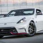 A white 2016 used Nissan 370z Nismo is parked in front of an industrial building.