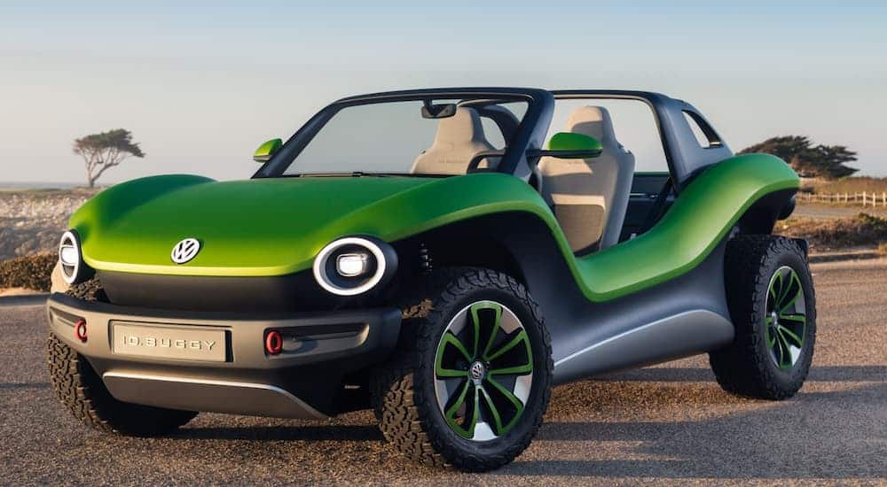 The green and black concept of the Volkswagen ID Buggy Concept EV is shown on a beach. 