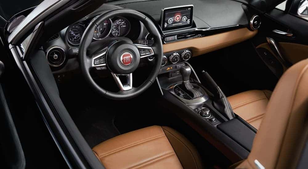 The black and brown leather interior, which is standard on the Fiat 124 Spider Lusso, is shown.