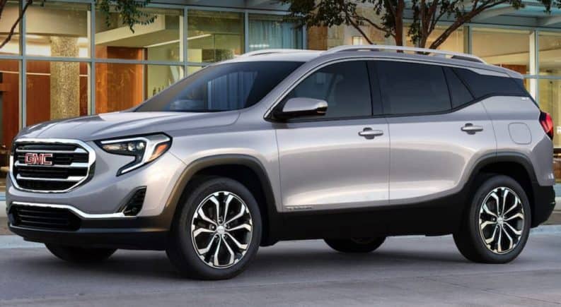 A silver 2019 GMC Terrain is parked in front of a house.