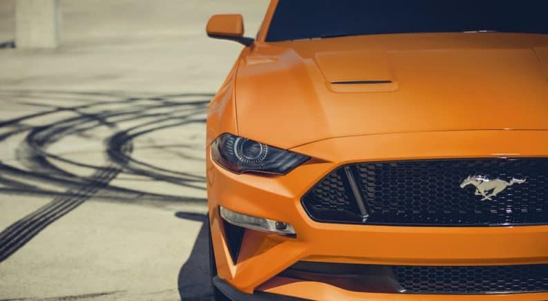 A close up of an orange 2020 Ford Mustang after doing burn outs.