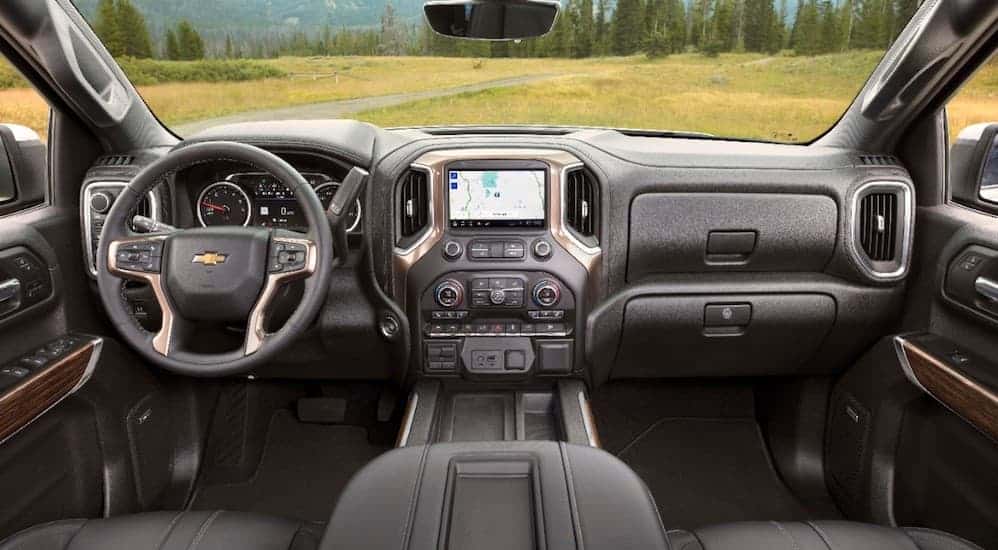The front black leather interior of a 2019 Chevy Silverado is shown. 