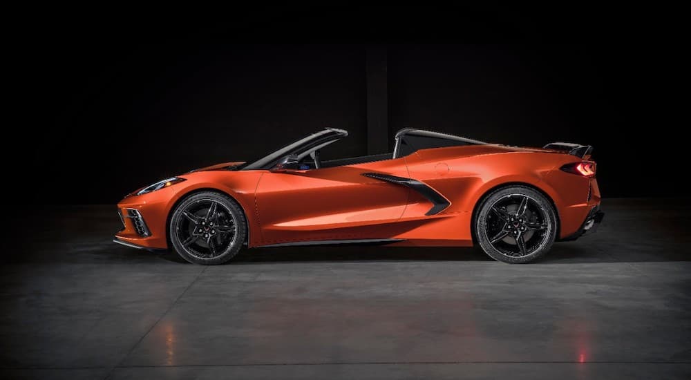 An orange 2020 Chevy Corvette is shown from the side with a black background.