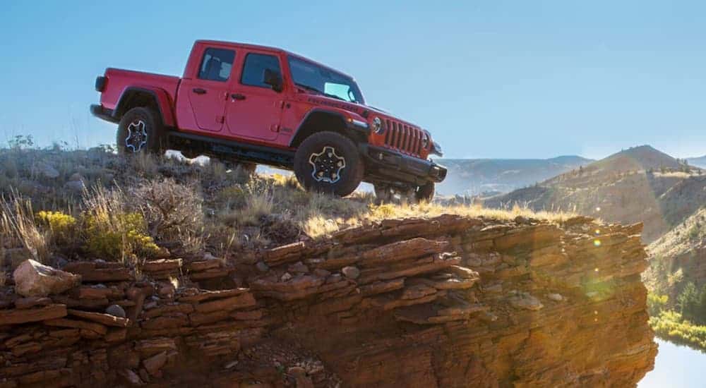 A red 2020 Jeep Gladiator Rubicon is parked on a hill looking over a valley.