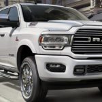A white 2019 Ram 2500 is driving on a city street.