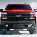 A red 2020 Chevy Silverado 1500 Trailboss is parked on a salt lot.