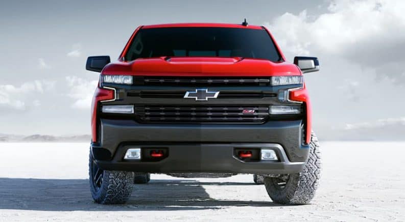 A red 2020 Chevy Silverado 1500 Trailboss is parked on a salt lot.