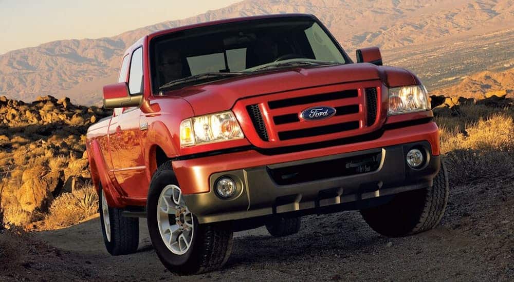 A red 2011 Ford Ranger, which is a popular option when looking at used Ford trucks, is parked on a dirt trail in the desert.