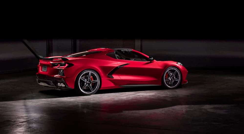 A red 2020 Chevy Corvette is parked in a dark lit garage. 
