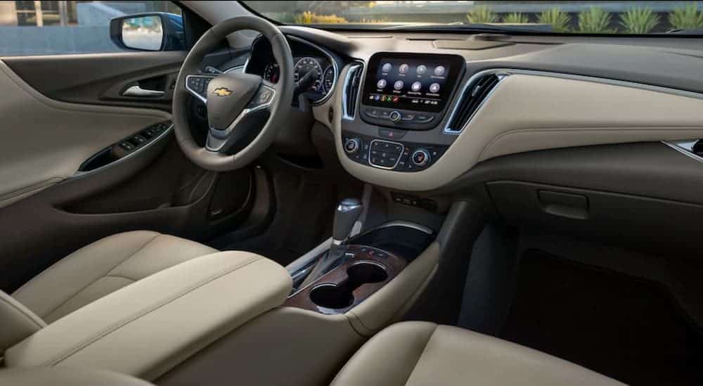 The front tan and grey interior of a 2020 Chevy Malibu is shown. 