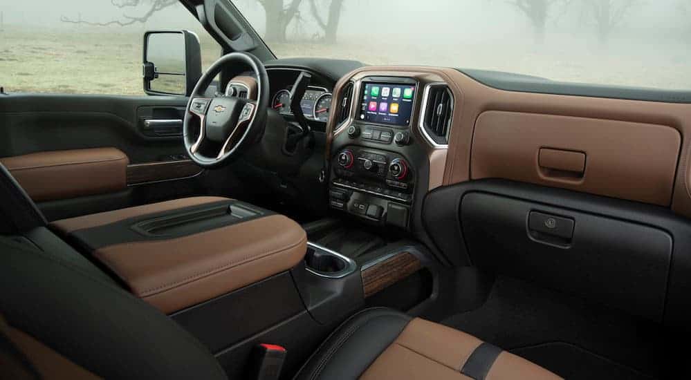 The front black and brown leather interior of the 2020 Silverado 2500HD is shown. 