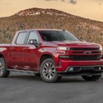 A red 2020 Chevy Silverado 1500, which wins when comparing the 2020 Chevy Silverado vs 2020 Ram 1500, is parked in front of a small mountain.