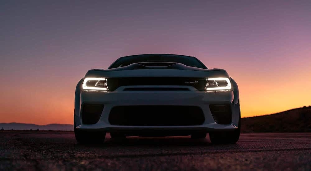 A white 2020 Dodge Charger is shown from the front at low angle during twilight.