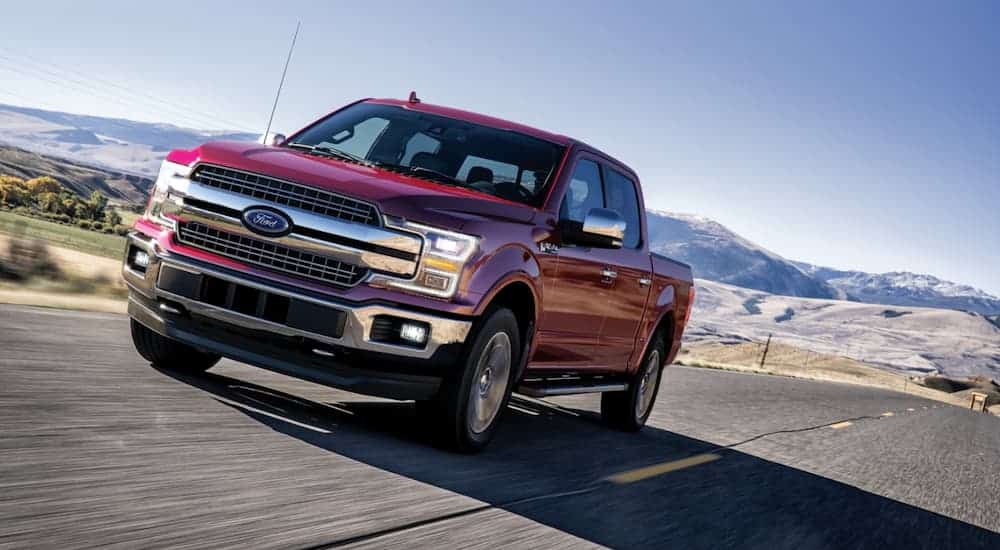 A red 2020 Ford F-150 is driving on a highway.