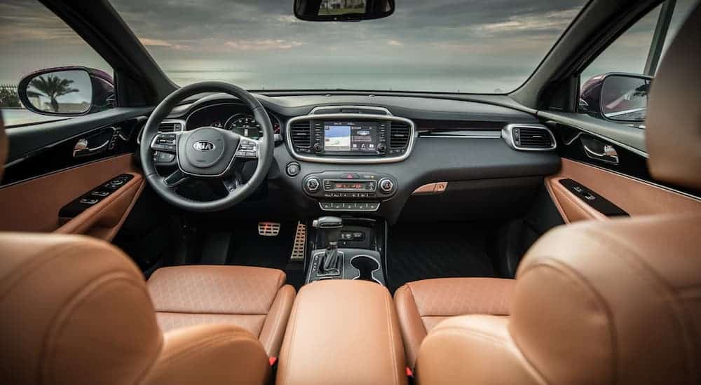 The front brown leather interior of a 2020 Kia Sorento is shown with an infotainment system. 