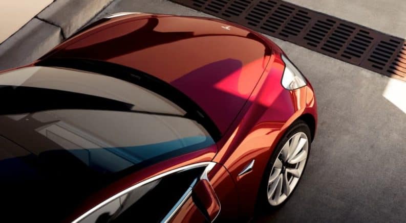 A birds eye view of a red 2019 Tesla Model 3 is shown.