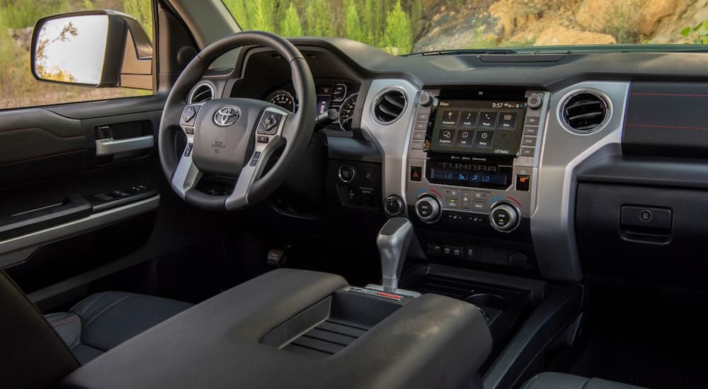 The front grey and black interior of a 2020 Toyota Tundra is shown with an infotainment system. 