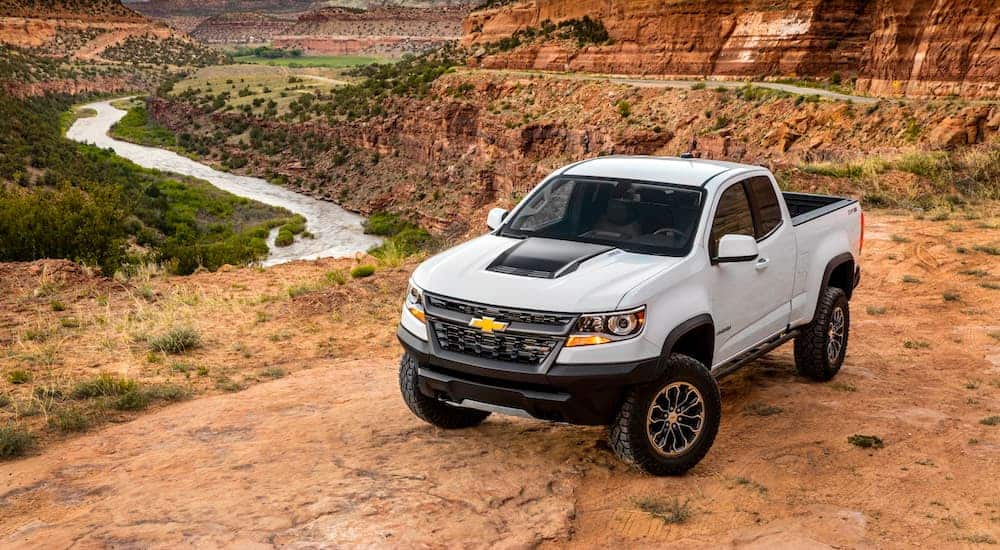 A birds eye view of a white 2020 Chevy Colorado ZR2 is shown while parked on a hill that's over looking a valley. 