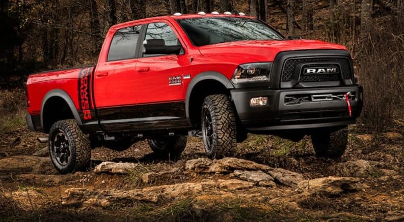 A red 2018 Ram 2500 Power Wagon is off-roading on a dirt trail.