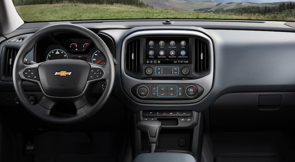The front black interior of a 2020 Chevy Colorado with an infotainment system is shown.