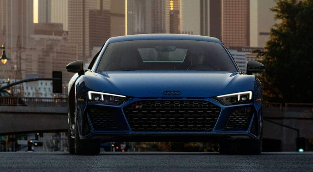 A blue 2020 Audi R8 Coupe is shown from the front in a city.