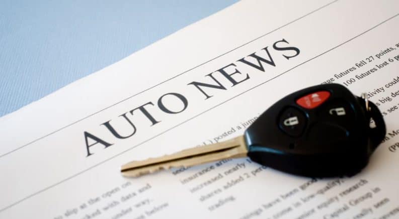 A newspaper that says "Auto News" with a car key on it is shown.