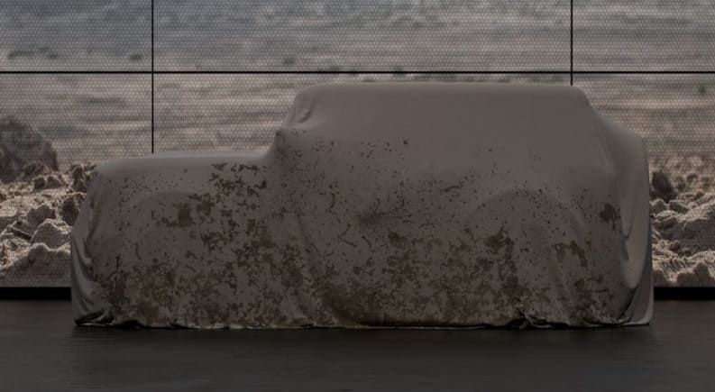 The all-new Ford Bronco is hidden under a brown cloth sheet.