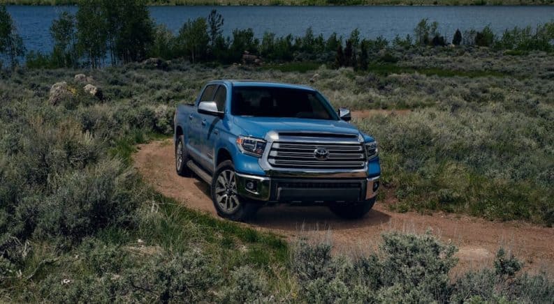 A blue 2020 Toyota Tundra, which is popular among Toyota models, is on a dirt trail.