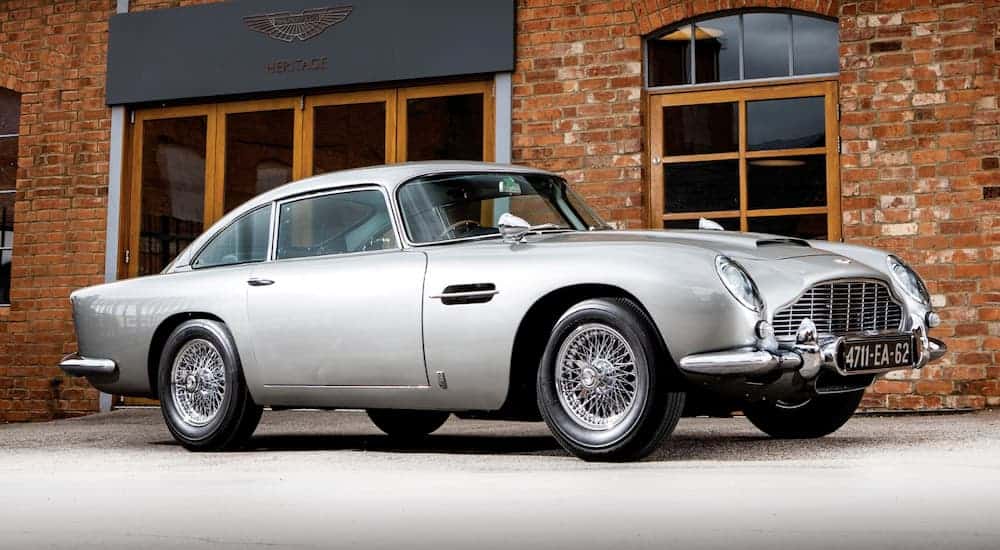 The silver 1965 Aston Martin DB5 Bond Car is in front of a brick building. Image: Simon Clay ©2019 Courtesy of RM Sotheby's