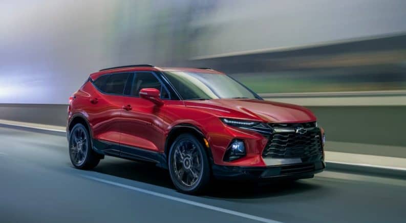 A red 2020 Chevy Blazer is driving past a blurred background after winning the 2020 Chevy Blazer vs 2020 Jeep Cherokee comparison.