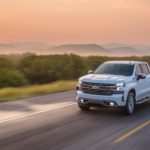 A white 2020 Chevy Silverado 1500 is driving at sunset after winning the 2020 Chevy Silverado vs 2020 Nissan Titan comparison.