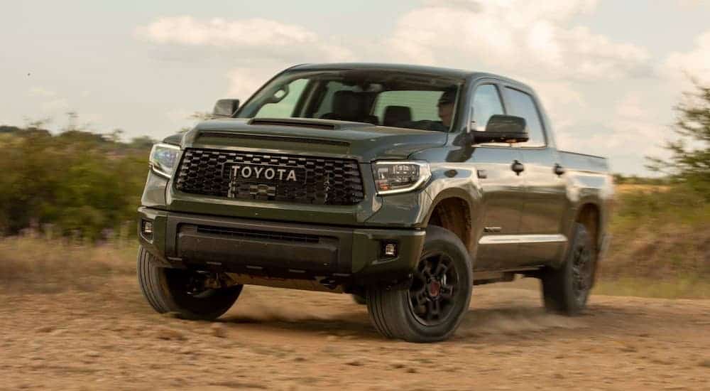 A green 2020 Toyota Tundra Tacoma TRD Pro is driving off-road in a desert.