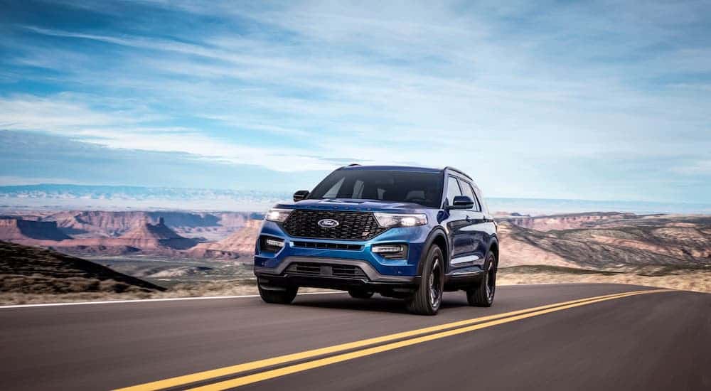 A blue Explorer ST is racing on a desert highway after winning 2020 Ford Explorer vs 2020 Jeep Grand Cherokee.