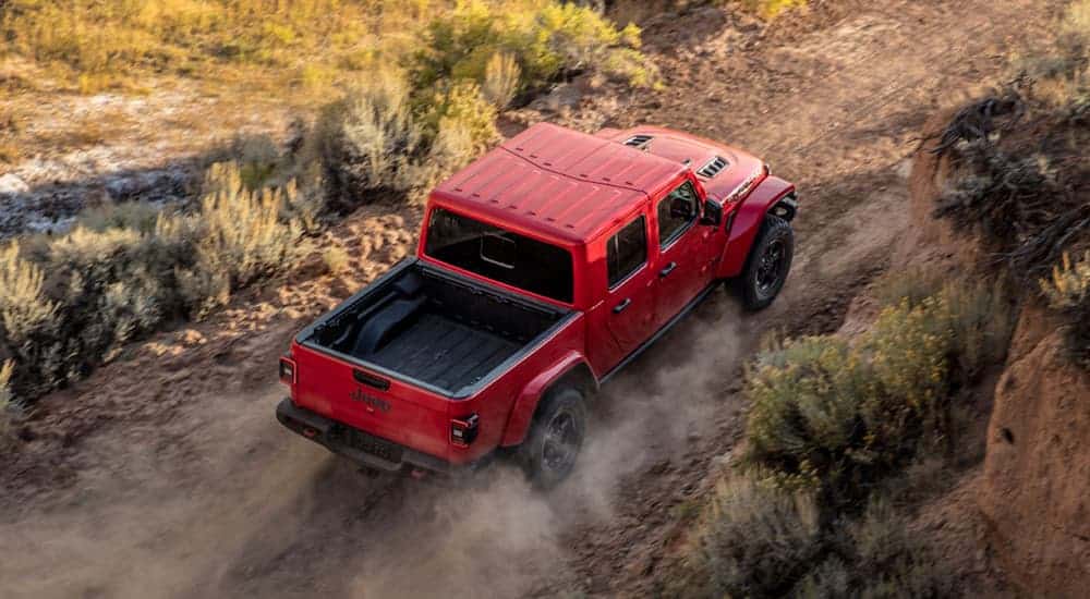 A red 2020 Jeep Gladiator is shown from above driving on a dirt road.