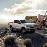 A silver 2020 Ford Ranger is parked on a cliff with a hang glider.