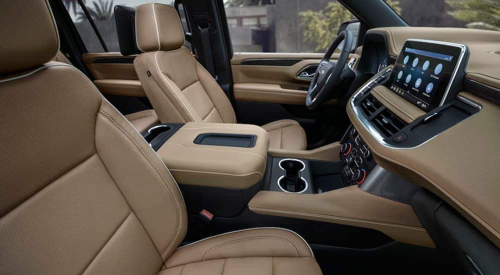 A side view of the front tan and black leather interior of a 2021 Chevy Suburban is shown.