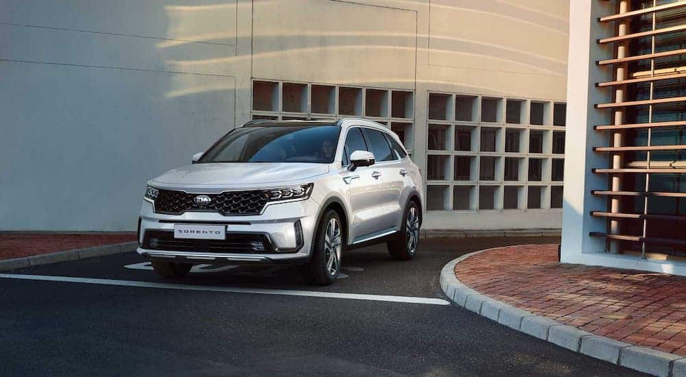 A white 2021 Kia Sorento is driving out of a parking garage.