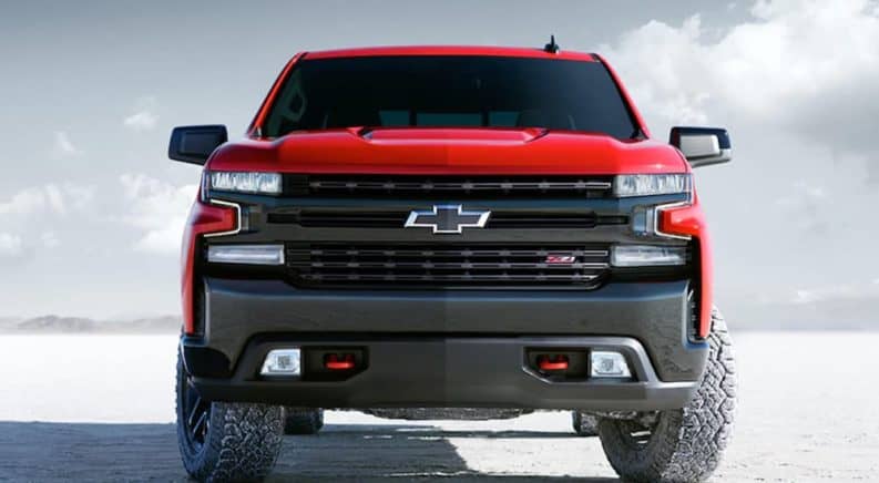 A red 2020 Chevy Silverado is parked on a flat salt land while facing forward.