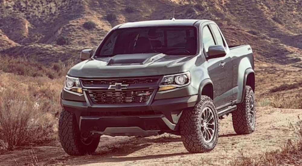 A dark grey 2020 Chevy Colorado ZR2 is driving on a dirt trail and is popular among Chevy trucks.
