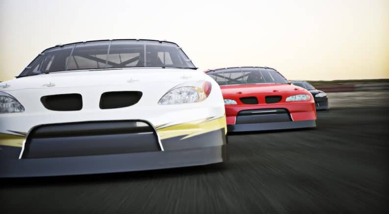 Race into a Chevy dealer near me, much like these white and red NASCAR cars racing on a track.