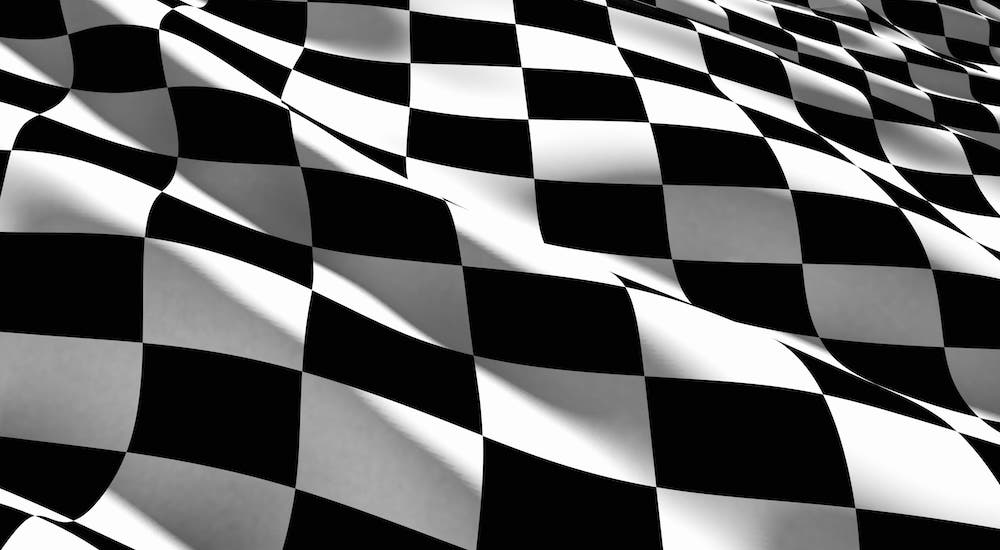 A closeup is shown of a wavy black and white checkered flag.