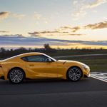 In current auto news, the 2021 Toyota Supra is taking off, shown here a yellow Supra is at the finish line of a racetrack.
