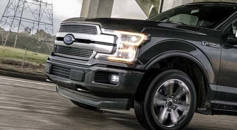 A closeup is shown of the grille of a black 2020 Ford F-150 Platinum.