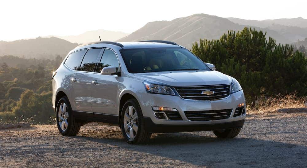 A silver 2016 Chevy Traverse is parked with mountain views and is popular among used SUVs for sale.