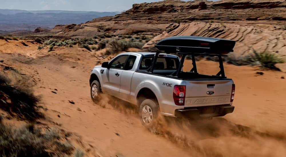 A silver 2020 Ford Ranger is racing through desert sand.