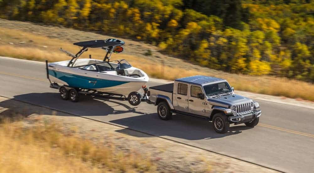 A grey 2020 Jeep Gladiator is towing a boat.