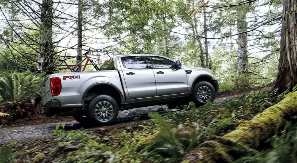 A silver 2020 Ford Ranger is off-roading in the woods.