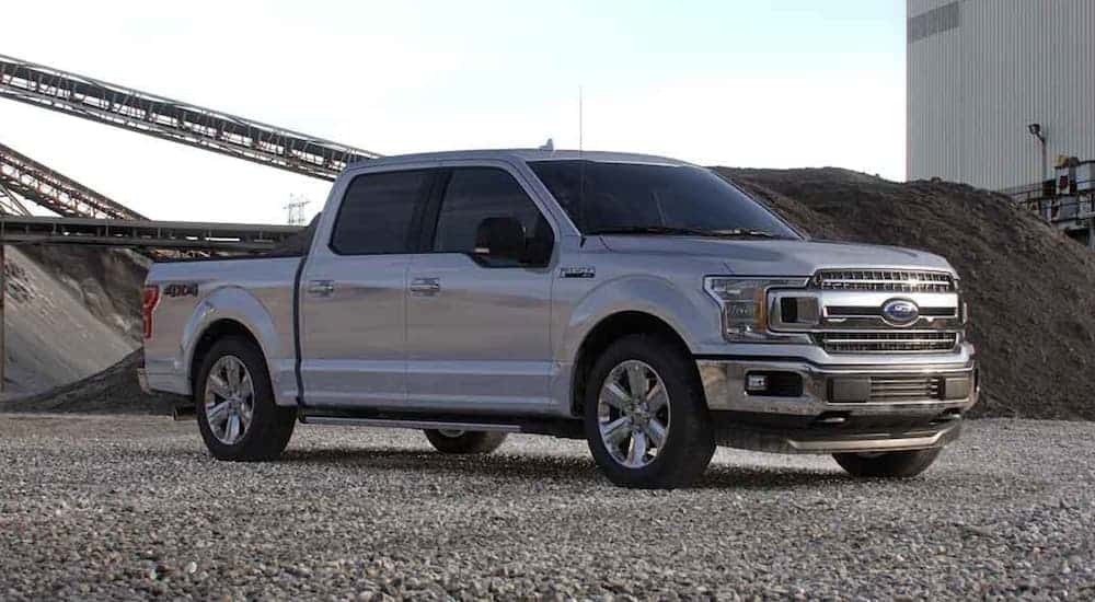 A silver 2020 Ford F-150 is parked in an industrial area.