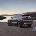 A brown and white 2021 Chevy Trailblazer ACTIV is parked in front of a lake at dusk.
